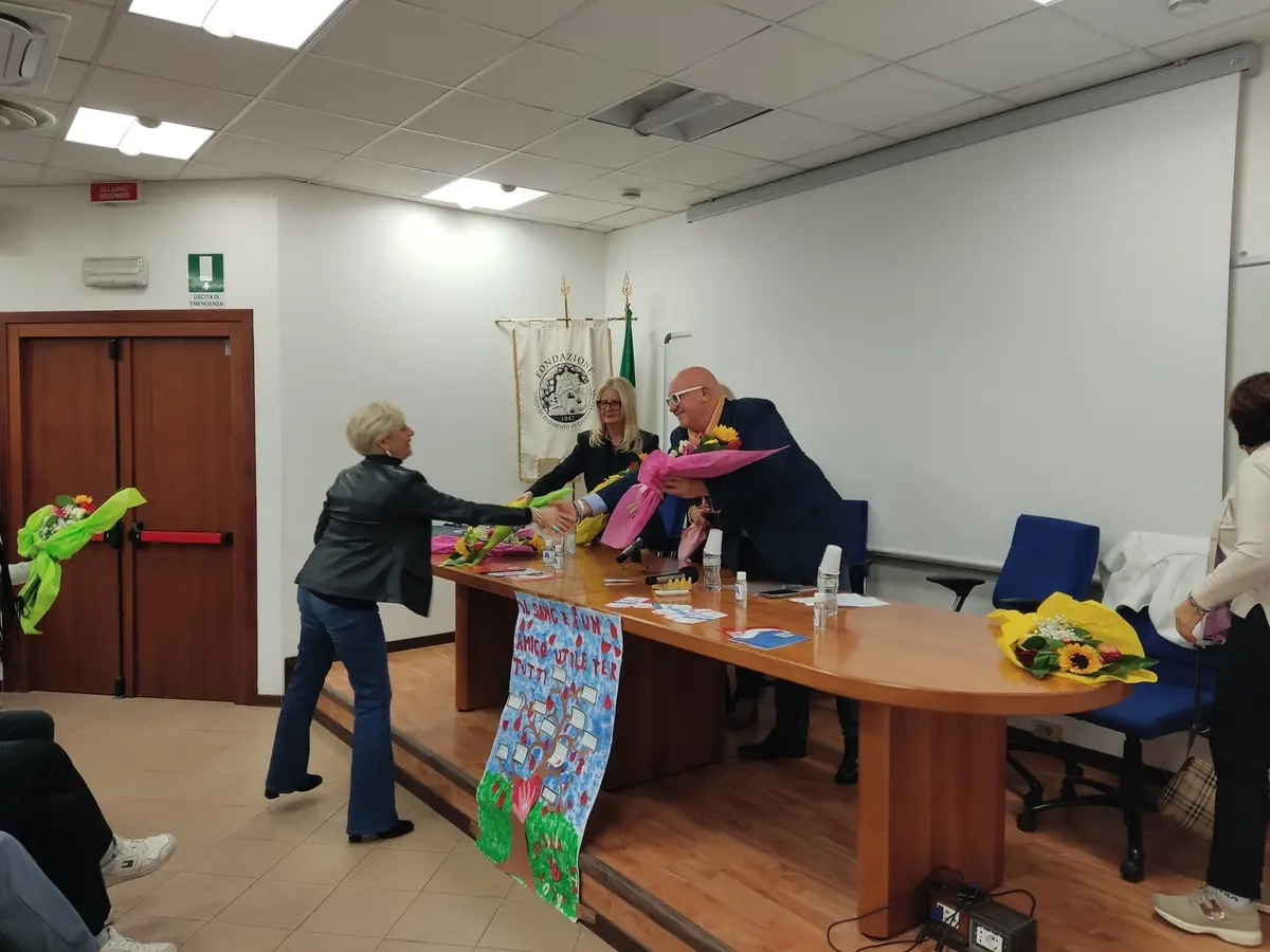 Il presidente dell'Avis di Civitavecchia Fabio Lisiola consegna un mazzo di fiori al dirigente scolastico dello Stendhal Maria Federici