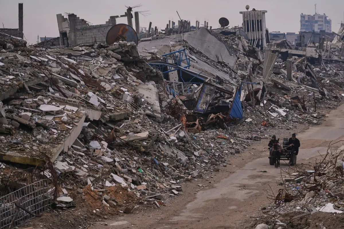 Palestinians pass along a street surrounded by buildings destroyed during Israeli air and ground operations in the Sheikh Radwan neighborhood, in Gaza City, Tuesday, Dec. 30, 2025. (AP Photo/Abdel Kareem Hana) Associate Press/ LaPresse Only Italy and Spain , APN