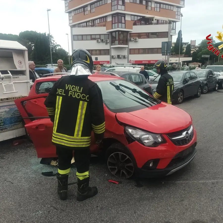 Auto perde il controllo, urta le vetture in sosta e colpisce il raccoglitore di abiti usati