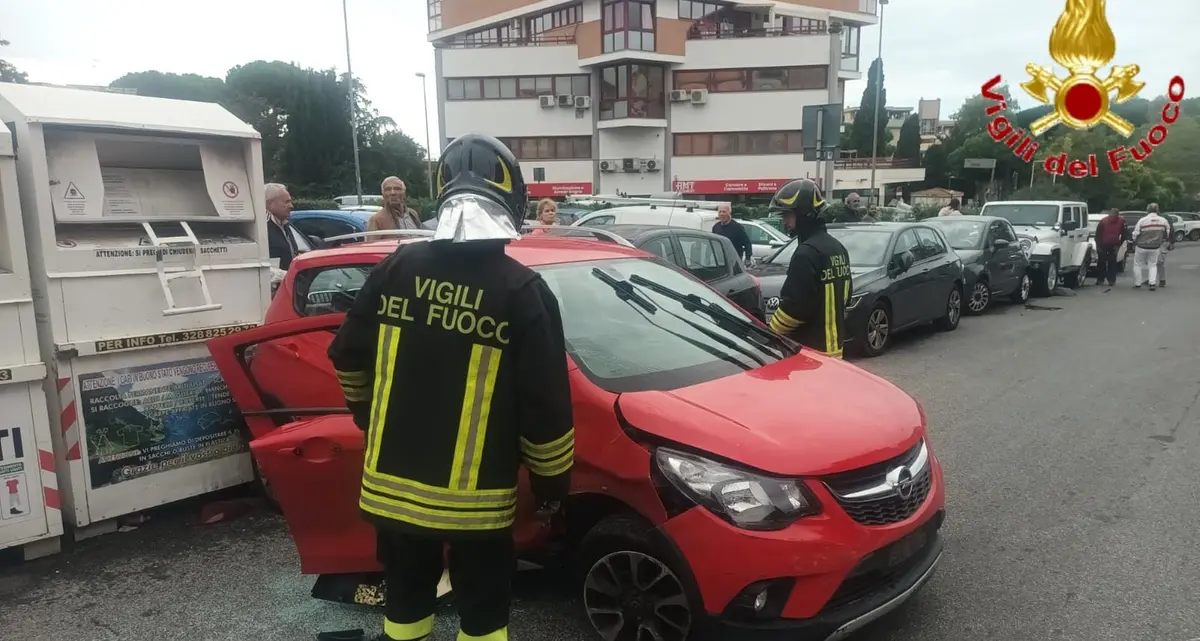 Auto perde il controllo, urta le vetture in sosta e colpisce il raccoglitore di abiti usati