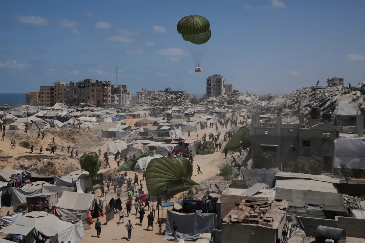 Palestinians rush to collect humanitarian aid airdropped by parachutes into Gaza City, northern Gaza Strip, Aug. 7, 2025. (AP Photo/Jehad Alshrafi) Associated Press/LaPresse , APN